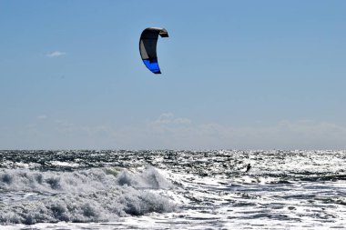 St. Augustine, Florida 'da çok rüzgarlı bir günde okyanus sahilinde uçurtma sörfçüsü.