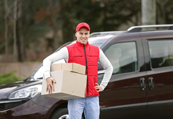 Jovem homem bonito entrega — Fotografia de Stock