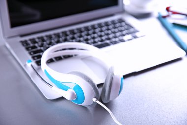 Masada kulaklık ve dizüstü bilgisayar var. 