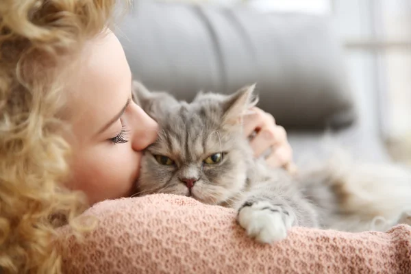 Woman and cat on sofa in the room — Stock Photo, Image