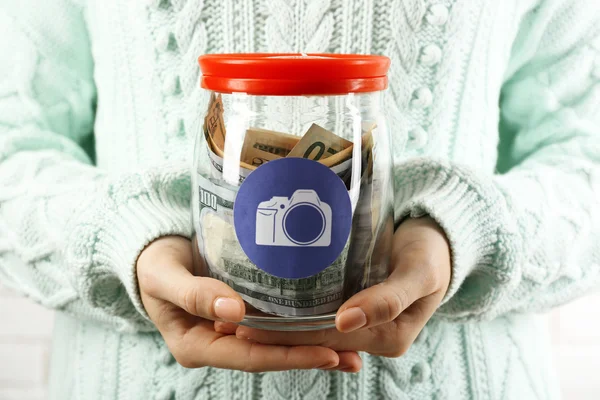 Žena ruce s penězi do sklenic — Stock fotografie