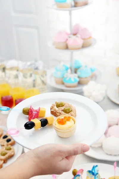 Vrouw bedrijf plaat met snacks — Stockfoto