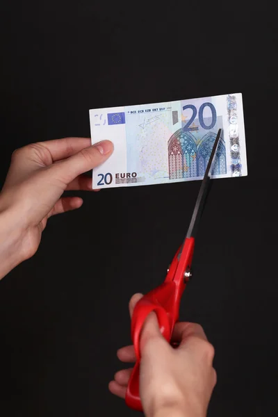 Руки с ножницами резки евро — стоковое фото
