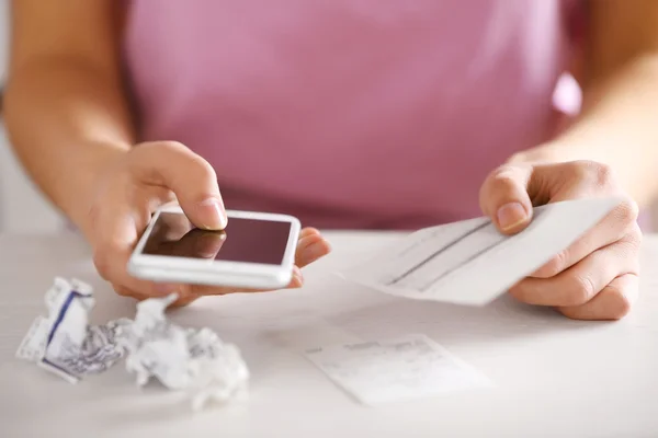 Woman with bills and smart phone — Stock Photo, Image
