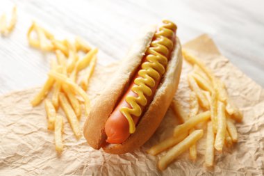 Sosisli sandviç ve patates kızartması ahşap arka plan üzerinde