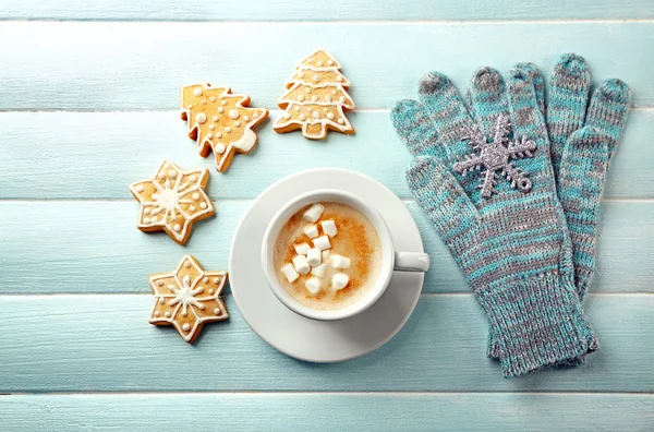 Tasse de cacao chaud avec guimauve, biscuits et gants chauds sur table bleue — Photo