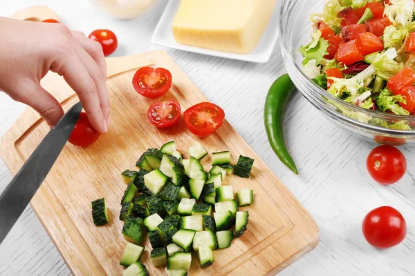 Las manos femeninas cortan hortalizas para la ensalada, a la cocina — Foto de Stock