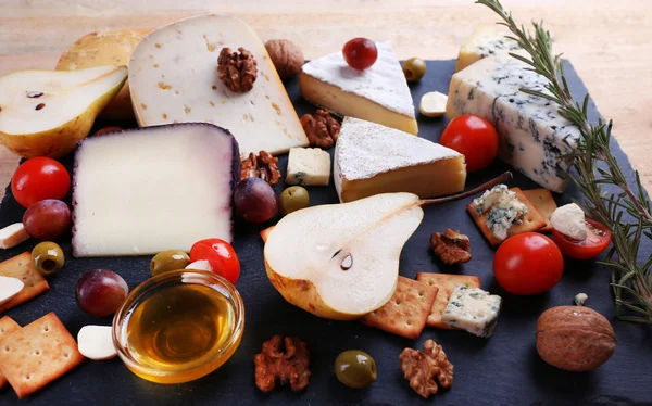 Diferentes tipos de queijo no fundo de madeira — Fotografia de Stock