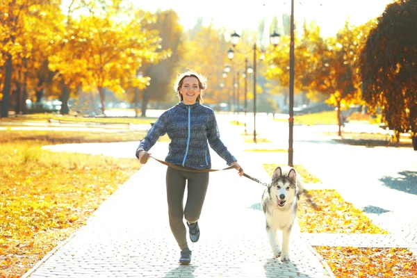 Donna che fa jogging con il cane nel parco — Foto Stock