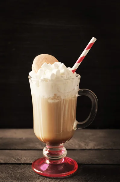 Kopp kaffe med vispgrädde och macaroon på svart bakgrund — Stockfoto