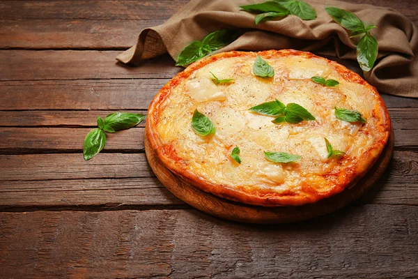 Tasty pizza decorated with basil