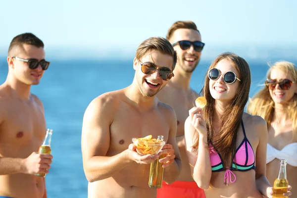 Happy friends drinking beer at beach — Stock Photo, Image