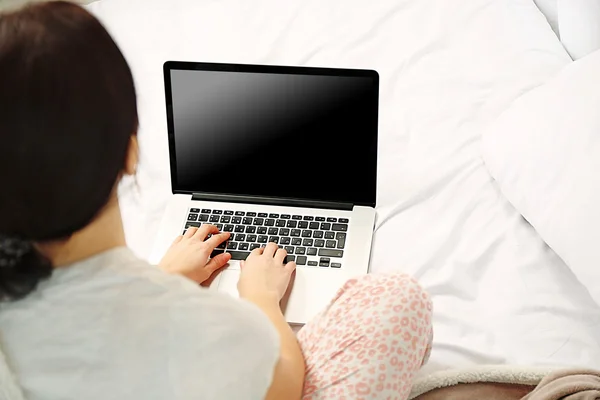 Kvinna i pyjamas med laptop — Stockfoto