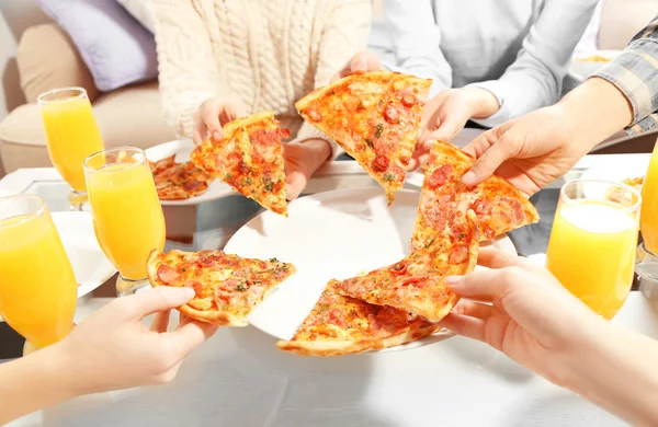 Vänner händer som håller varm pizza — Stockfoto