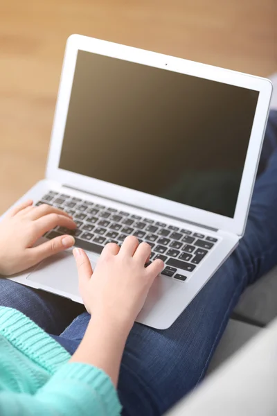 Woman sitting on sofa with laptop — Stock Photo, Image