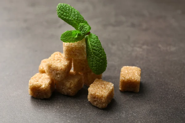 Montón de terrones de azúcar morena y stevia en la mesa, de cerca — Foto de Stock