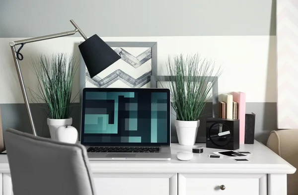 Arbetsplatsen med bord, lampa och bärbar dator i vardagsrummet — Stockfoto