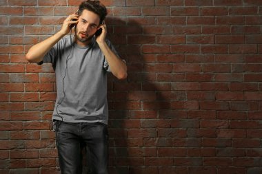 Kulaklıkla müzik dinleyen genç adam. 