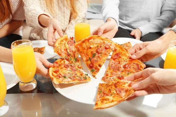 Amigos manos sosteniendo pizza caliente —  Fotos de Stock
