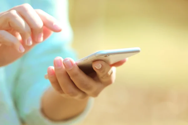 Manos femeninas sosteniendo un teléfono móvil — Foto de Stock