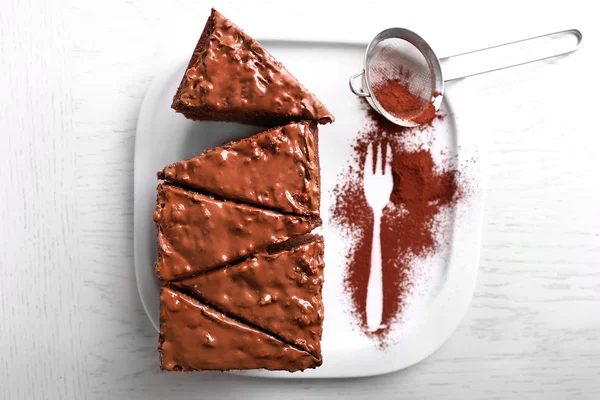 Смачний нарізаний шоколадний торт з горіховим кремом на білій тарілці, крупним планом — стокове фото