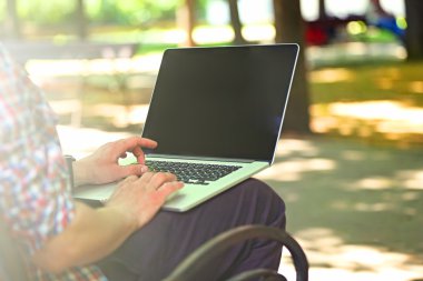 Park içinde laptop ile çalışan adam