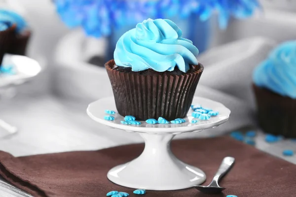 Läcker choklad cupcake med blå grädde serveras tabellen, närbild — Stockfoto