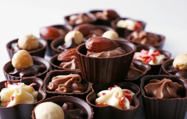 Lahodné čokoládové bonbony na bílém pozadí, zblízka — Stock fotografie