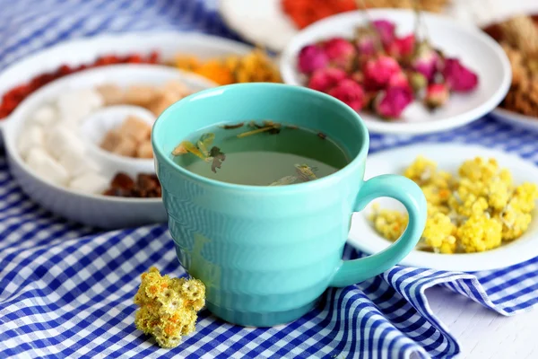 Tazza di tè con tè aromatico secco su sfondo di legno — Foto Stock