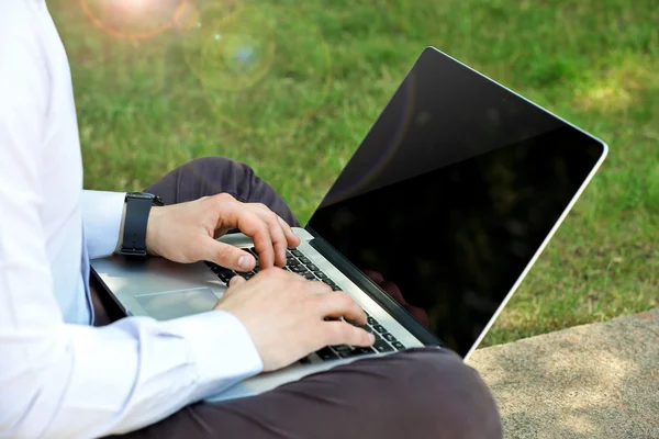 Homme travaillant avec ordinateur portable dans le parc — Photo