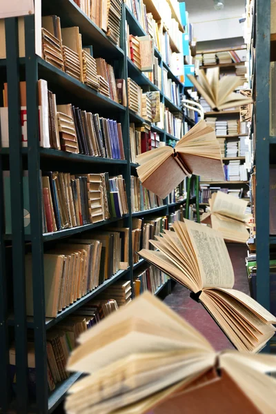 Libros voladores en estanterías de bibliotecas — Foto de Stock