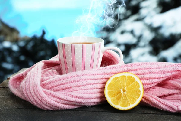 Beautiful winter composition with cup of hot drink on windowsill against snow landscape from outside. — Stock Photo, Image