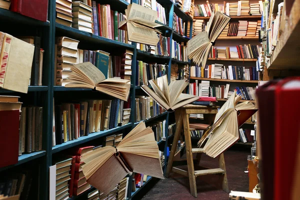 Flying books on library bookshelves — Stock Photo, Image