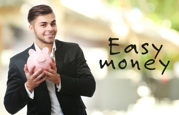 Hombre con alcancía y billetes — Foto de Stock