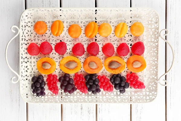 Fruit candies on tray on wooden background — Stock Photo, Image