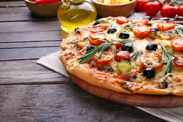 Heerlijke verse pizza op houten tafel closeup — Stockfoto