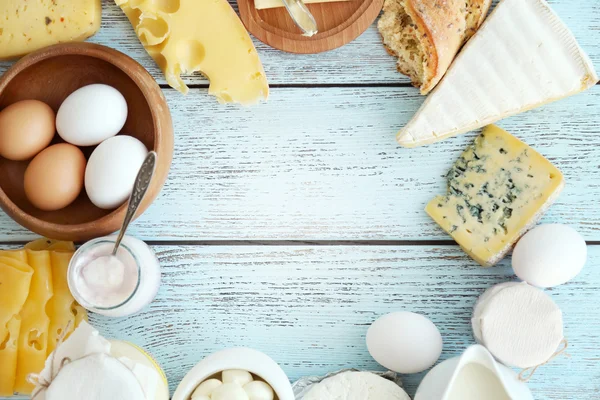 Marco de productos lácteos frescos sobre mesa de madera azul — Foto de Stock