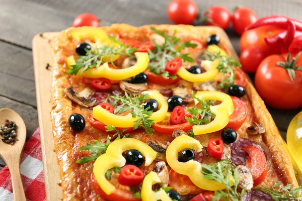 Prostokąt pyszne pizze i warzywa na stole — Zdjęcie stockowe