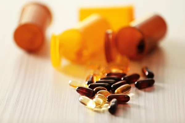 Verschillende capsules gemorst uit pil flessen — Stockfoto