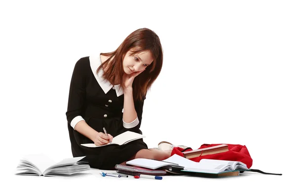 Bela colegial com saco escolar escrevendo em notebook — Fotografia de Stock