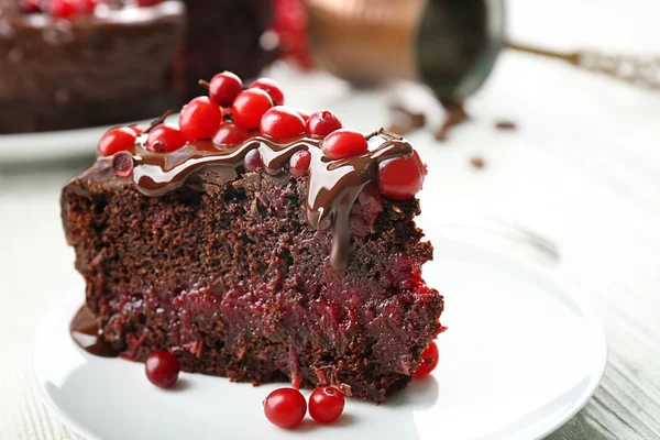 Stuk chocolade cake met veenbessen op plaat, close-up — Stockfoto
