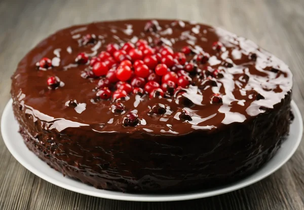 Schokoladenkuchen mit Preiselbeeren auf Holztisch, Nahaufnahme — Stockfoto