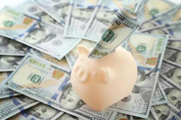 Piggy bank op stapel dollars — Stockfoto