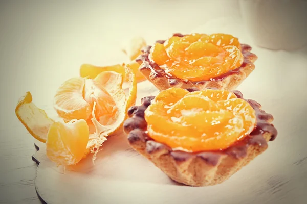 Gâteaux sucrés avec mandarines sur la table, gros plan — Photo