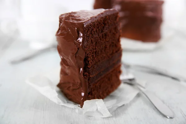 Een stuk van chocolade taart met vorken op houten tafel achtergrond, close-up — Stockfoto