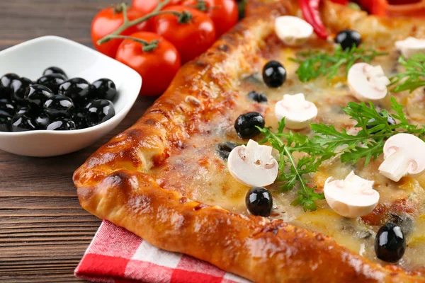 Frisch gemachte Pizza auf Holztisch in Großaufnahme — Stockfoto