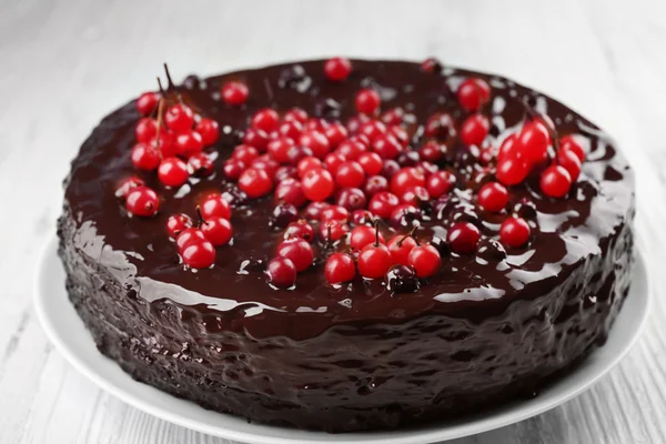 Chocolate cake with cranberries on white wooden table, closeup — Stock Photo, Image