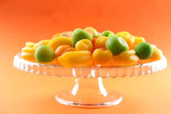 Фруктовые конфеты на фоне апельсина — стоковое фото