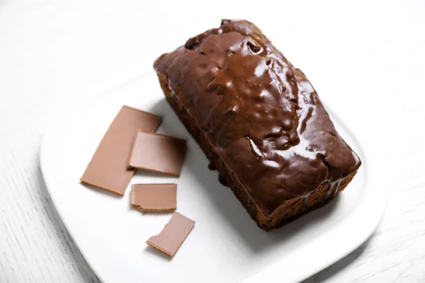Bolo de chocolate com cobertura na mesa branca — Fotografia de Stock
