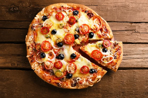 Deliziosa pizza fresca sul tavolo di legno, vista dall'alto — Foto Stock